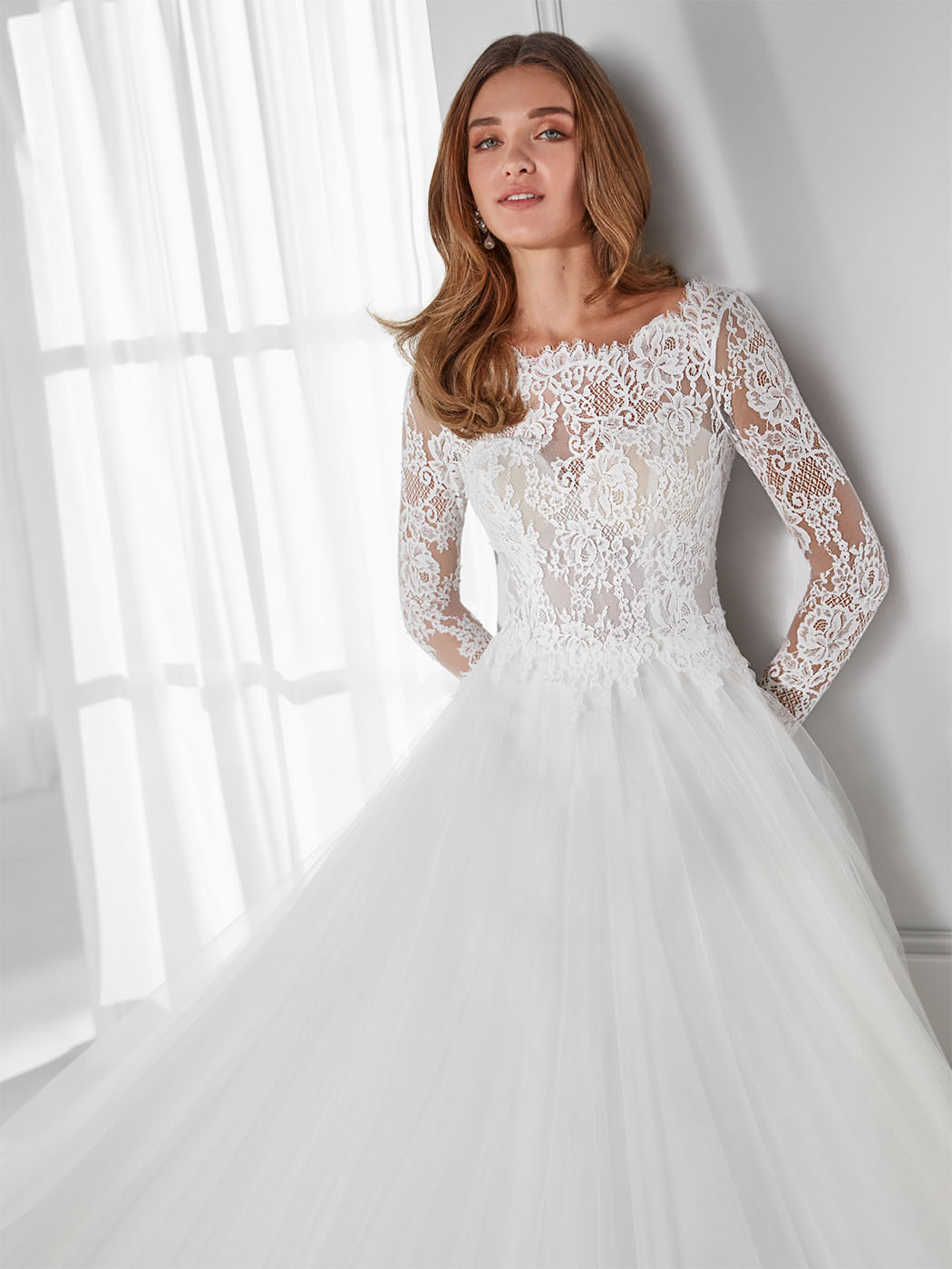 Abito da sposa in tulle, pizzo, scollo bateau alto e strascico